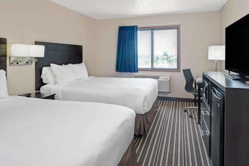 奥马哈Super 8 by Wyndham Omaha I-80 West的酒店客房设有两张床和一台平面电视。