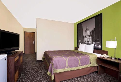 曼西曼西速8酒店的配有一张床和一台平面电视的酒店客房