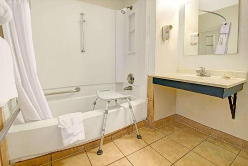 拉斯克鲁塞斯Super 8 by Wyndham Las Cruces University Area的浴室配有盥洗盆、浴缸和盥洗盆