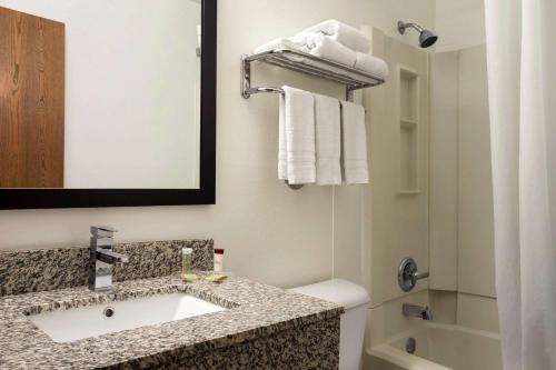 锡达拉皮兹锡达拉皮兹东速8酒店的一间带水槽、卫生间和镜子的浴室