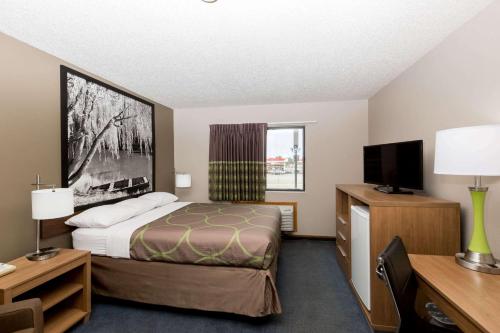 海斯速8海斯酒店的配有一张床和一台平面电视的酒店客房