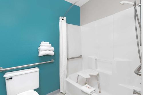 HuronSuper 8 by Wyndham Huron的浴室设有白色卫生间和蓝色的墙壁。