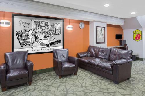 温莎温莎/北麦迪逊速8酒店的一间设有两张皮椅和一张沙发的等候室