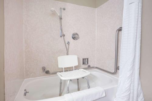 大瀑布城Grizzly Inn的浴室内带椅子的白色浴缸
