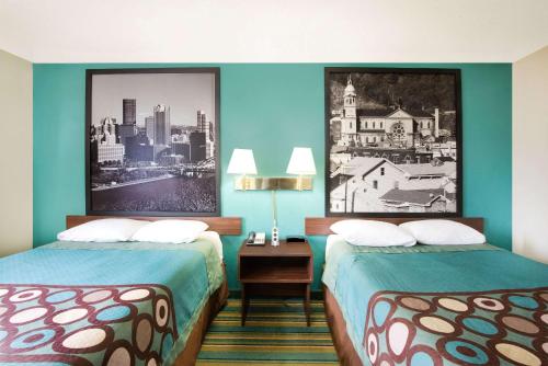 月球乡Super 8 by Wyndham Pittsburgh PA Airport-University Area的酒店客房设有两张床,墙上挂着一张照片。