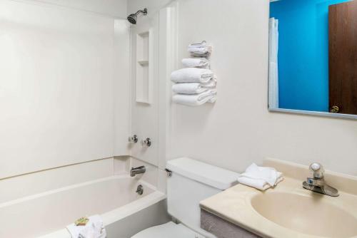 林垦林肯西速8酒店的白色的浴室设有水槽、卫生间和浴缸。