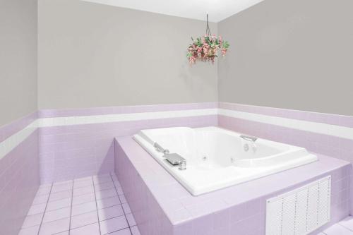 Howe豪速8酒店的白色的浴室设有花卉布置的浴缸