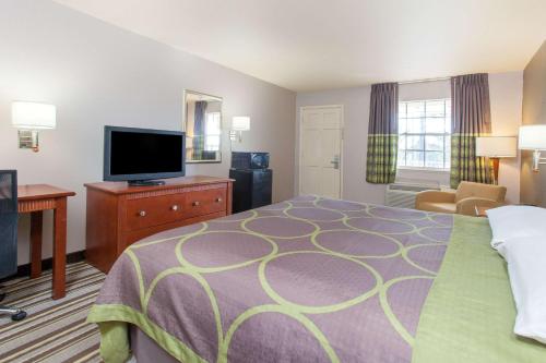 西门罗Super 8 by Wyndham West Monroe的配有一张床和一台平面电视的酒店客房