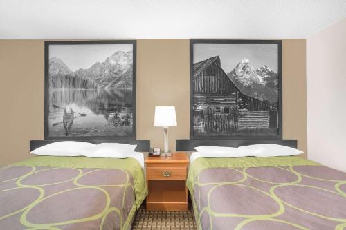 里弗顿弗顿速8汽车旅馆的两张床铺,位于酒店客房,墙上挂有绘画作品