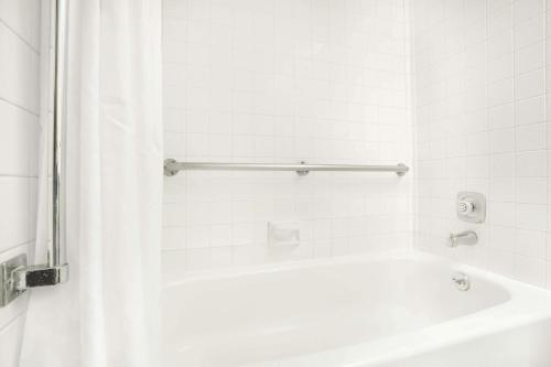 里弗顿弗顿速8汽车旅馆的白色的浴室设有浴缸和淋浴。