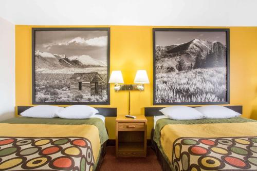 埃尔科埃尔科超级8的两张床位于带黄色墙壁的酒店客房
