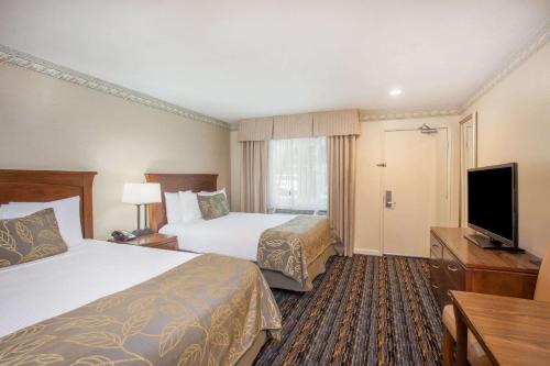 圣地亚哥Days Inn by Wyndham San Diego Hotel Circle的酒店客房设有两张床和一台平面电视。