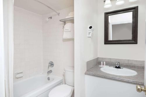 坎布里奇速8剑桥酒店的白色的浴室设有卫生间和水槽。