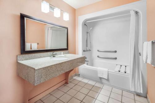 帕勒斯坦Premier Inn的一间带水槽、浴缸和镜子的浴室
