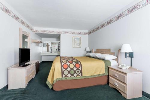 卡顿伍德速8杨木酒店的配有一张床和一台平面电视的酒店客房