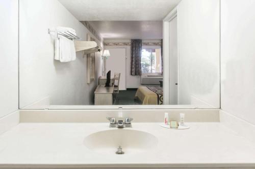 卡顿伍德速8杨木酒店的一间带水槽和大镜子的浴室