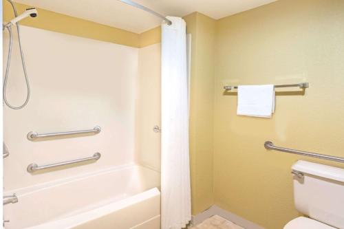 杰赛普杰塞普/巴尔的摩地区速8酒店的带浴缸、卫生间和淋浴的浴室。