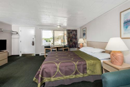 西雅茅斯西茅斯海恩尼斯/科德角速8汽车旅馆的酒店客房设有一张大床和一张书桌。