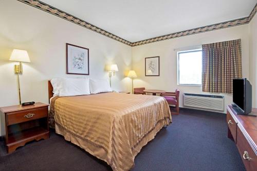 伯克利圣路易斯旅游旅馆的配有一张床和一台平面电视的酒店客房