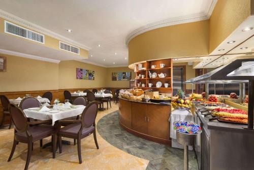 阿布扎比Howard Johnson by Wyndham Abu Dhabi Downtown的一间带桌椅的餐厅以及一间自助餐