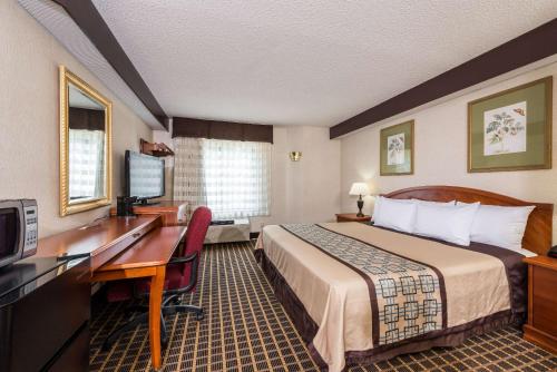 Yadkinville德金维尔戴斯酒店的配有一张床和一张书桌的酒店客房