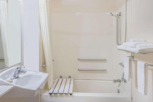 萨利纳萨利纳席林路速8汽车旅馆的白色的浴室设有水槽和浴缸。