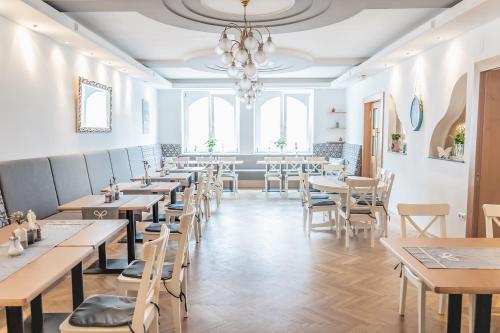 施泰格斯巴赫Landhotel Stegersbach的一间带桌椅和吊灯的餐厅