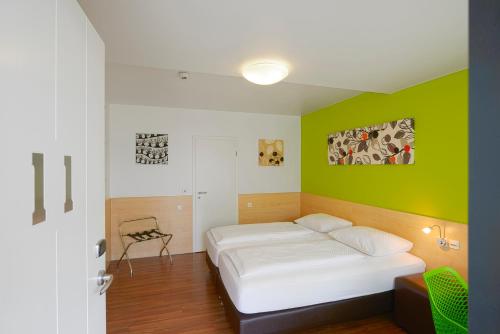 索斯特索斯特城市汽车旅馆的一间卧室设有一张床和绿色的墙壁