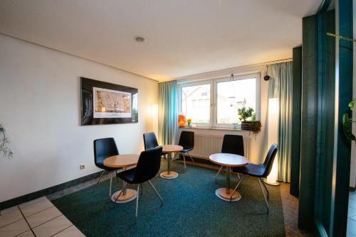 Schnelldorf雷斯登斯酒店的一间设有四张桌子和椅子的房间,以及一个窗户
