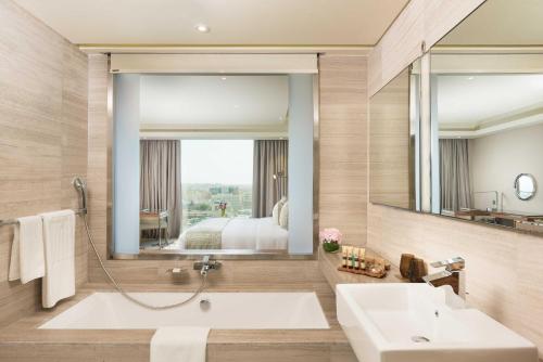 马斯喀特马斯喀特千禧国际酒店的一间带浴缸和大镜子的浴室