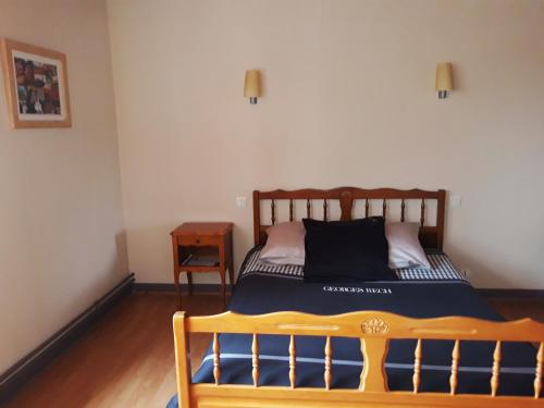 Saint-Aubin-le-Monial圣欧班酒店的一间卧室配有一张木架床