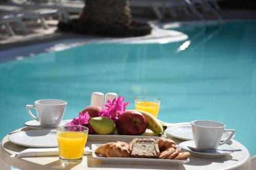 卡马利Arion Bay Hotel的池畔餐桌上的早餐盘