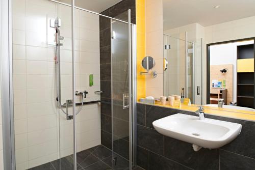古尔克古尔克斯提聚福酒店的一间带水槽和玻璃淋浴的浴室
