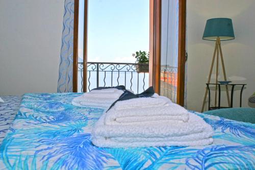 希拉Piana delle Galee的一张带毛巾的床和窗户