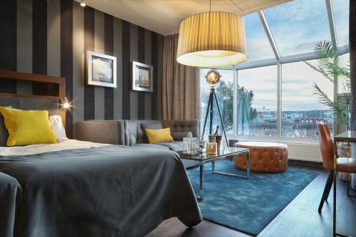 斯泰农松德斯特努斯巴登游艇俱乐部酒店的一间卧室配有一张床、一张沙发和一张桌子