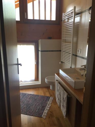 圣博沃Lausen Vil的一间带水槽和卫生间的浴室以及窗户。
