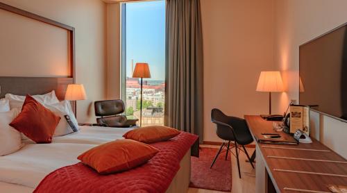 赫尔辛基赫尔辛基克拉丽奥酒店的配有一张床、一张书桌和一扇窗户的酒店客房