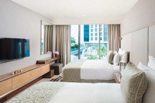 马斯喀特马斯喀特千禧国际酒店的配有一张床和一台平面电视的酒店客房