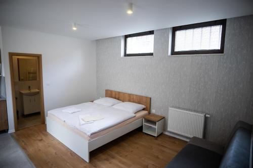 波切尼斯Ubytovanie Alej Bojnice的卧室配有白色的床和2扇窗户。