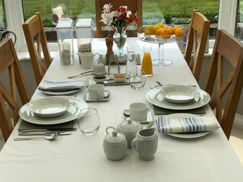 米德赫斯特Hysett House的一张带盘子和玻璃杯的白色桌子