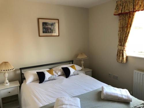 奥克姆Jubilee House的一间卧室配有带白色床单和枕头的床。