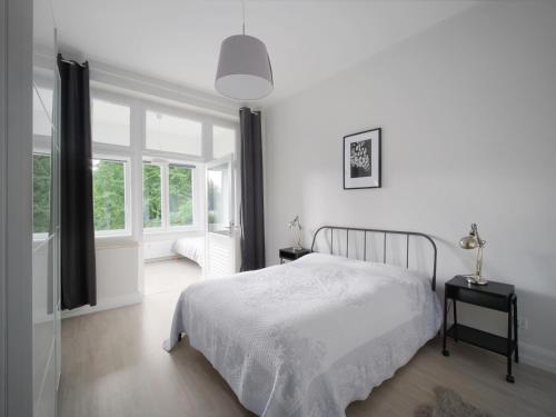 锡格堡锡格堡城市公寓的白色的卧室设有床和窗户