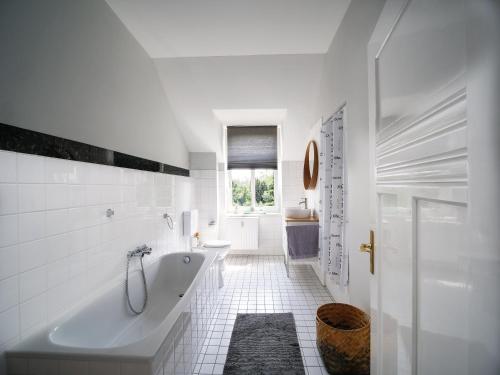 锡格堡锡格堡城市公寓的白色的浴室设有浴缸和水槽。