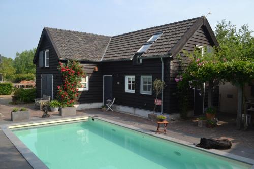 Sint-OedenrodeHet Steenuiltje的房屋前有游泳池的房子