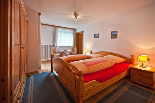 迈尔霍芬Haus St. Christoph的一间卧室配有一张带红色毯子的木床
