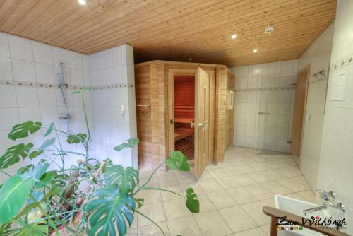 施尔奇Ferienanlage Zum Wildbach Schierke的带淋浴的浴室和木制天花板