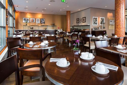 科隆圣多酒店的一间带木桌椅的餐厅和一间用餐室