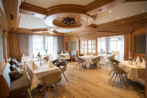 哈伦贝格索尔兰德尔豪夫酒店的餐厅设有白色的桌椅和窗户。