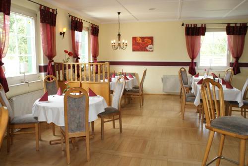奥斯特西巴德钦诺维茨卡斯坍尼恩霍夫加尼酒店的一间配备有桌椅和红色窗帘的用餐室