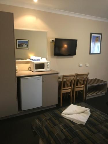 古尔本贝克豪斯汽车旅馆的酒店客房在带椅子的柜台上配有微波炉